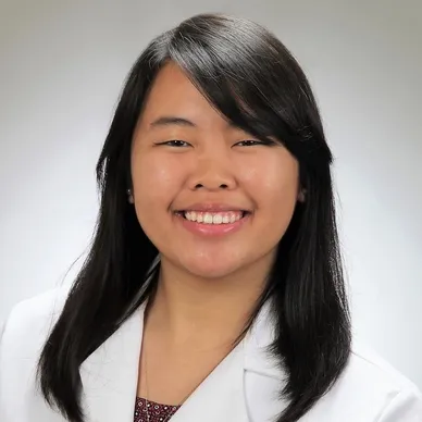 A headshot of a black haired dentist.